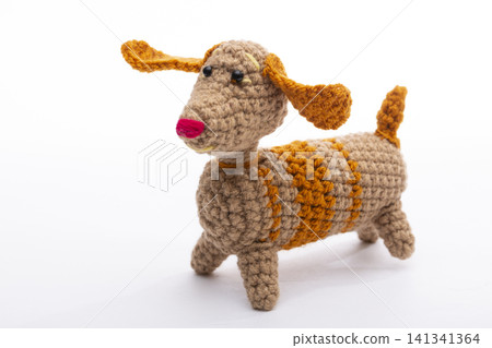 Knitted woolen dog on a white background Knitted woolen dog on a white background 141341364