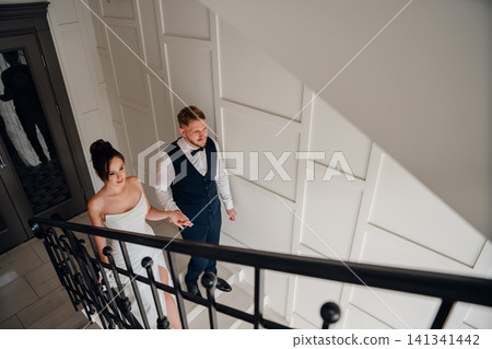 Portrait of a beautiful groom and a bride on the stairs Portrait of a beautiful groom and a bride on the stairs 141341442