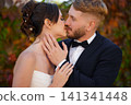 Beautiful and in love bride and groom against the background of autumn foliage. 141341448