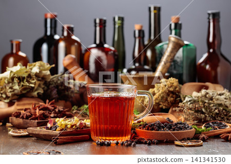 Herbal tea on an old wooden table with dried herbs, fruit, and spices. Herbal tea on an old wooden table with dried herbs, fruit, and spices. 141341530