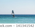 Windsurfing on the board with a sail on the sea waves 141341542