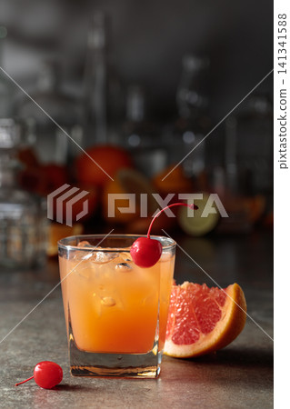 Cocktail with ice and grapefruit juice garnished with maraschino cherry. Cocktail with ice and grapefruit juice garnished with maraschino cherry. 141341588