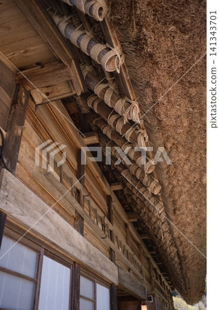 用繩子將椽子綁在茅草屋頂的屋簷上:傳統的日本老房子建築 用繩子將椽子綁在茅草屋頂的屋簷上:傳統的日本老房子建築 141343701