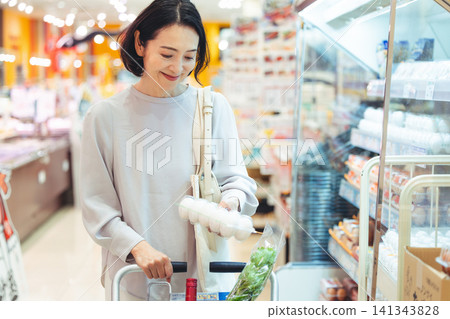 A woman buying eggs at the supermarket A woman buying eggs at the supermarket 141343828