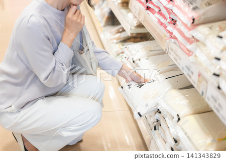 一位女士對超市裡的米價感到困擾。 一位女士對超市裡的米價感到困擾。 141343829