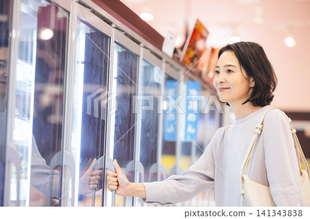 一位家庭主婦正在冷凍食品區挑選商品。 141343838