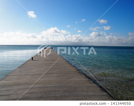 Okinawa, Taketomi Island: A breathtaking view of the West Pier leading to the crystal-clear emerald green sea and the blue sky. Okinawa, Taketomi Island: A breathtaking view of the West Pier leading to the crystal-clear emerald green sea and the blue sky. 141344050