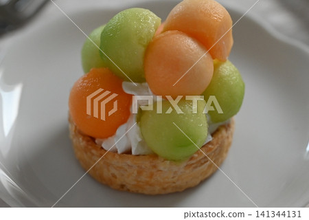 A tart cake generously filled with melon pulp. A tart cake generously filled with melon pulp. 141344131