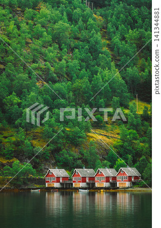 Classic red Norwegian boathouses along the edge of the fjord. Sognefjord port in Flam, Norway. Red wooden Docks in small tourist town of Flam on western side of Norway deep in fjords. Classic red Norwegian boathouses along the edge of the fjord. Sognefjord port in Flam, Norway. Red wooden Docks in small tourist town of Flam on western side of Norway deep in fjords. 141344881