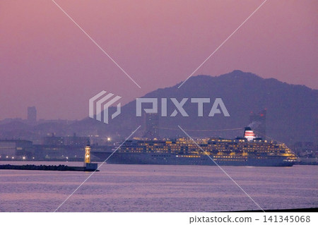 The cruise ship "Asuka II" departing Kobe Port at dusk, with the Kobe Port First Breakwater East Lighthouse (viewed from Port Island West Green Space). The cruise ship "Asuka II" departing Kobe Port at dusk, with the Kobe Port First Breakwater East Lighthouse (viewed from Port Island West Green Space). 141345068