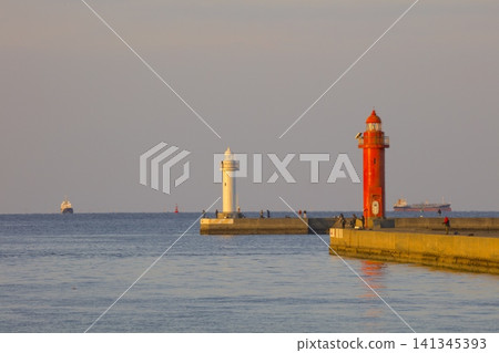A red and white lighthouse at the tip of Himeji Port, bathed in the morning sun. A red and white lighthouse at the tip of Himeji Port, bathed in the morning sun. 141345393