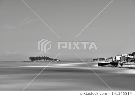 A monochrome long-exposure photograph of Enoshima and Mount Fuji from Inamuragasaki Park on the Shonan coast, with white waves crashing against the water. A monochrome long-exposure photograph of Enoshima and Mount Fuji from Inamuragasaki Park on the Shonan coast, with white waves crashing against the water. 141345514