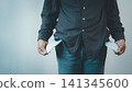Man showing empty pockets indicating he is broke and has no money. Financial crisis, debt, poor, and bankrupt business concept. 141345600