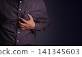 Adult man holding his chest experiencing a severe heart attack and chest pain. Medical, healthcare, and cardiovascular disease emergency concept. 141345603
