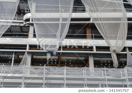 A construction site for steel frame construction with folded mesh sheets. A construction site for steel frame construction with folded mesh sheets. 141345707