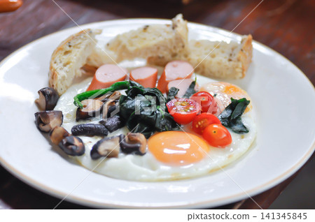 fried egg or sunny side up egg with vegetable topping and bread or breakfast fried egg or sunny side up egg with vegetable topping and bread or breakfast 141345845
