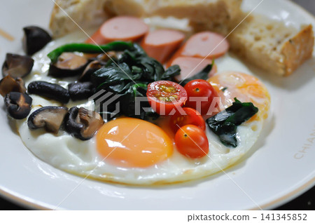 fried egg or sunny side up egg with vegetable topping and bread or breakfast fried egg or sunny side up egg with vegetable topping and bread or breakfast 141345852