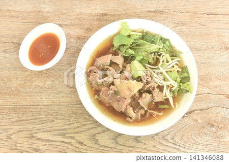 boiled braised and slice fresh beef meat and tendon in herb brown soup on plate with spicy chili sour sauce boiled braised and slice fresh beef meat and tendon in herb brown soup on plate with spicy chili sour sauce 141346088