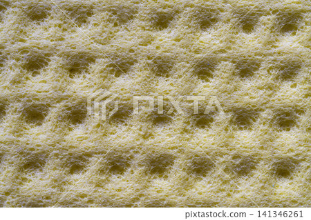 Close up view of a yellow sponge with a waffle-like texture. 141346261
