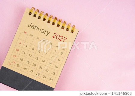 Brown desk calendar for January 2027 on pink background. Brown desk calendar for January 2027 on pink background. 141346503