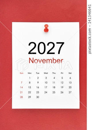 November 2027 calendar page with push pin on red color background. November 2027 calendar page with push pin on red color background. 141346641