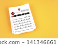 October 2027 calendar page with wooden push pin on yellow background. 141346661