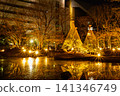 Koishikawa Korakuen Garden, with its beautiful golden reflection on the water's surface and two snow-covered trees, January 2024. 141346749