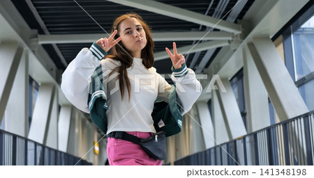 Full length urban trendsetter striking pose, colorful skirt and fanny pack, varsity jacket layered for contrast, confident playful energy, low angle perspective, streetwear aesthetic, vibrant content Full length urban trendsetter striking pose, colorful skirt and fanny pack, varsity jacket layered for contrast, confident playful energy, low angle perspective, streetwear aesthetic, vibrant content 141348198