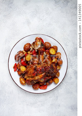 Pork knuckle baked with vegetables, new potatoes , on a white plate, homemade, no people, Pork knuckle baked with vegetables, new potatoes , on a white plate, homemade, no people, 141349005