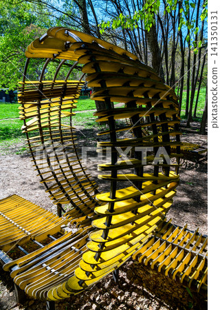 Yellow curved bench sculpture in a park Yellow curved bench sculpture in a park 141350131
