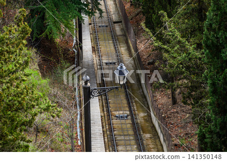 Funicular railway tracks on a steep wooded hillside Funicular railway tracks on a steep wooded hillside 141350148