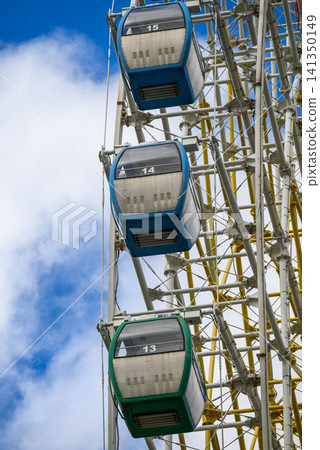 Colorful ferris wheel cabins against blue sky Colorful ferris wheel cabins against blue sky 141350149