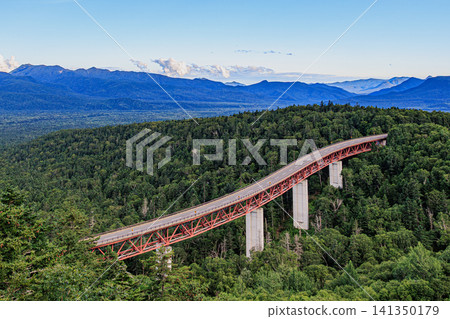 The beautiful red Matsumi Bridge stretches above the deep primeval forest, and the summer sky is dynamic. The beautiful red Matsumi Bridge stretches above the deep primeval forest, and the summer sky is dynamic. 141350179