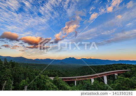Matsumi Bridge spanning the deep forest of Daisetsuzan National Park and the gradient of the evening sky. Matsumi Bridge spanning the deep forest of Daisetsuzan National Park and the gradient of the evening sky. 141350191