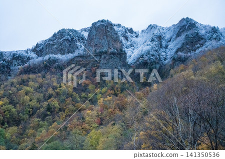 Steep, rocky mountains covered in the first snow Steep, rocky mountains covered in the first snow 141350536