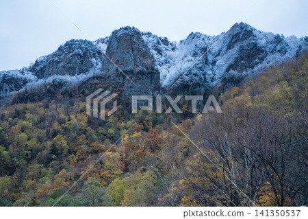 Snow-capped rocky peaks and mountains in autumn colors Snow-capped rocky peaks and mountains in autumn colors 141350537