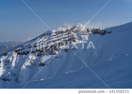 A snowstorm sweeps across the mountaintop in winter. A snowstorm sweeps across the mountaintop in winter. 141350573
