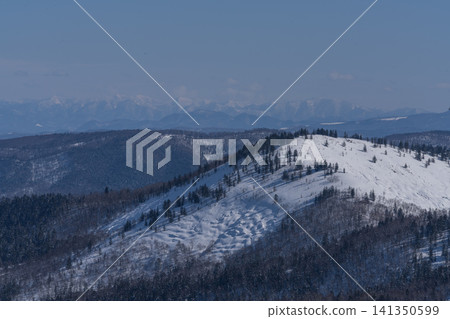 遠處是層巒疊嶂的藍色山脊和白雪皚皚的山峰。 141350599