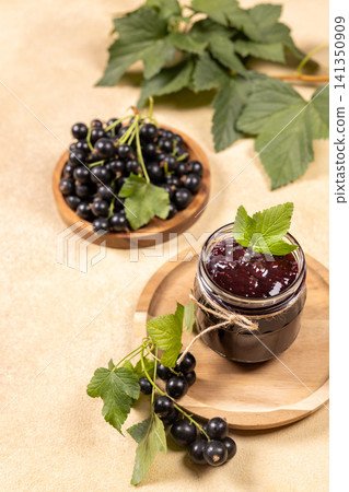 Blackcurrant jam jar with fresh berries and leaves Blackcurrant jam jar with fresh berries and leaves 141350909