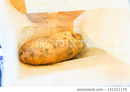 Takeout roasted sweet potatoes from my Kagoshima trip in a white bag. Takeout roasted sweet potatoes from my Kagoshima trip in a white bag. 141351176