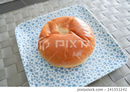 A breakfast plate featuring a round, fluffy loaf of bread viewed from an angle. A breakfast plate featuring a round, fluffy loaf of bread viewed from an angle. 141351242