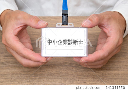 一名男子的雙手拿著一張寫著「認證中小企業管理顧問」的名牌。 141351550