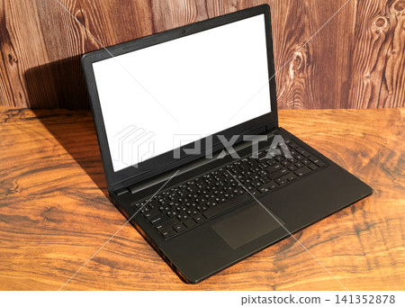 open laptop with a white screen stands on a wooden table surface at an angle open laptop with a white screen stands on a wooden table surface at an angle 141352878
