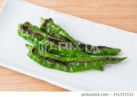 Grilled Manganji peppers served on a square plate Grilled Manganji peppers served on a square plate 141353532