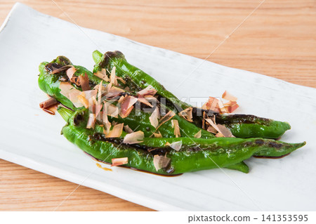 Grilled Manganji peppers topped with bonito flakes and soy sauce Grilled Manganji peppers topped with bonito flakes and soy sauce 141353595