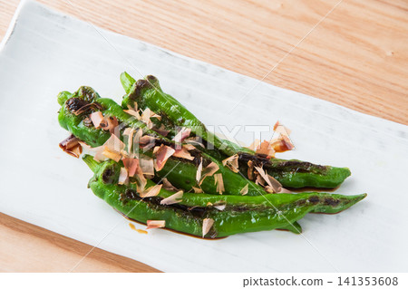 烤滿乾辣椒,撒上鰹魚片和醬油 烤滿乾辣椒,撒上鰹魚片和醬油 141353608