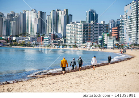 Tourists walk on Gwangalli beach gulf with city skyscraper, Busan Tourists walk on Gwangalli beach gulf with city skyscraper, Busan 141355991