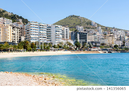 Beautiful beach with white pebbles and blue waters in european city. Beautiful beach with white pebbles and blue waters in european city. 141356065