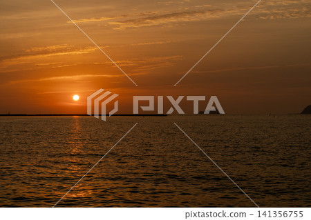 A beautiful sunset sinking into the sea and the water's surface dyed golden. A beautiful sunset sinking into the sea and the water's surface dyed golden. 141356755
