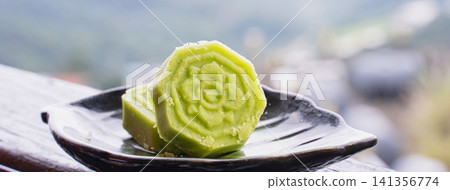 Green Tea Mooncake on Black Plate, Asian Dessert Close-Up Green Tea Mooncake on Black Plate, Asian Dessert Close-Up 141356774